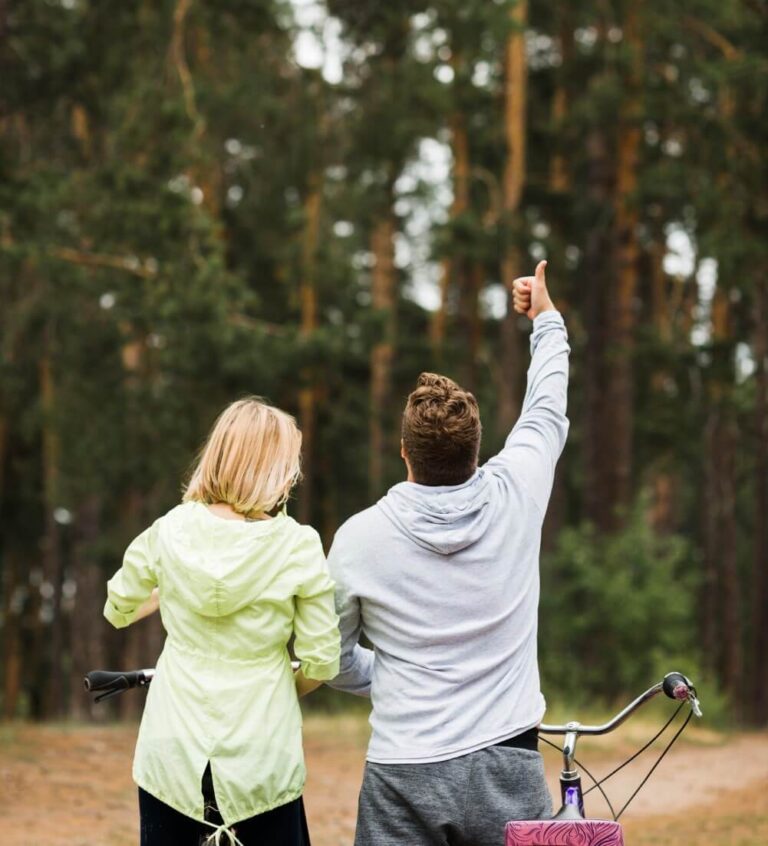 A couple walking in the woods, enjoying a bike ride, with one giving a thumbs-up at Family Acupuncture Clinic Jacksonville.
